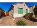 Rear view of the house with a wooden gate and gravel landscaping at 790 W Jardin Dr, Casa Grande, AZ 85122