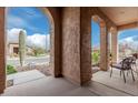 Covered patio with arched entryway, comfortable seating, and views of the neighborhood at 8047 W Cinder Brook Way, Florence, AZ 85132