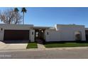 Contemporary single-story home featuring a two-car garage, manicured lawn, and desert landscaping at 8165 E Del Cuarzo Dr, Scottsdale, AZ 85258