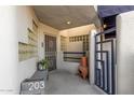 Condo entrance with security gate, bench, and terracotta pot at 902 W Glendale Ave # 203, Phoenix, AZ 85021