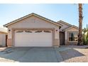 Tan house with a two-car garage and a palm tree in the front yard at 9233 E Lobo Ave, Mesa, AZ 85209