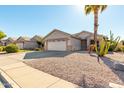 House with a two-car garage and desert landscaping at 9233 E Lobo Ave, Mesa, AZ 85209