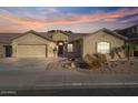 Tan house with tile roof, two-car garage, and desert landscaping at 9758 E Meseto Ave, Mesa, AZ 85209