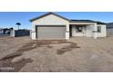 New construction home with gray garage door and desert landscaping at 13586 S Kashmir Rd, Arizona City, AZ 85123