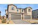 Charming townhome featuring a two-car garage, neutral stucco, stone accents, and modern architectural style at 21028 N 58Th Way, Phoenix, AZ 85054