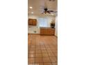 Kitchen boasts wood cabinets, tile floor, and a ceiling fan at 321 S Bridge St, Superior, AZ 85173