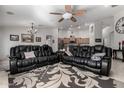 Relaxing living room with two black leather sofas and a large area rug at 3479 E Esplanade Ct, Gilbert, AZ 85297