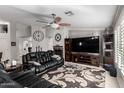 Spacious living room with leather furniture, a large TV, and a fireplace at 3479 E Esplanade Ct, Gilbert, AZ 85297