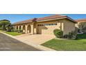Tan house with arched entryways, red tile roof, and a two-car garage at 7927 E Sage Dr, Scottsdale, AZ 85250