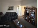 Cozy living room featuring a sofa, coffee table, and built-in shelving at 12103 W Rosewood Dr, El Mirage, AZ 85335