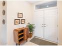 Inviting entryway with a unique wooden cabinet and a view of double doors at 14309 W Rico Dr, Sun City West, AZ 85375