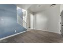 Bright living room with blue accent wall and wood-look tile floors at 20673 N Marquez Dr, Maricopa, AZ 85138