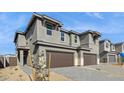 A modern home showcases a spacious three-car garage, stylish stone accents, and professionally designed landscaping at 21016 N 58Th Way, Phoenix, AZ 85054