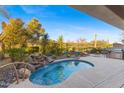 Inviting kidney-shaped pool with waterfall feature at 2164 W Muirfield Dr, Anthem, AZ 85086