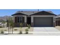 Charming single-story home featuring a neutral color palette, stone accents, and a well-manicured front yard at 22311 W Monona Ln, Surprise, AZ 85387
