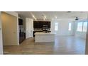 Modern kitchen featuring dark wood cabinets, stainless steel appliances, a center island, and wood look tile at 22311 W Monona Ln, Surprise, AZ 85387