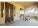 Covered front porch with seating area and security door at 30034 N 128Th Ave, Peoria, AZ 85383