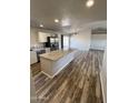 Open concept kitchen with island and wood-look flooring at 34902 W Caldwell St, Tonopah, AZ 85354