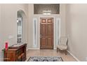 Bright entryway with tile flooring, chair, and wooden console table at 3817 E Cielo Grande Ave, Phoenix, AZ 85050