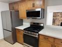 Stainless steel appliances and wood cabinets in this updated kitchen at 3941 E Emile Zola Ave, Phoenix, AZ 85032