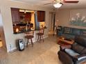 Open kitchen with breakfast bar and view into living room at 5215 W Acapulco W Ln, Glendale, AZ 85306