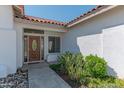 Front entry with a wood door, tile flooring and landscaping at 5335 W Bloomfield Rd, Glendale, AZ 85304