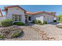 White stucco home with tile roof, landscaping, and a two-car garage at 5335 W Bloomfield Rd, Glendale, AZ 85304