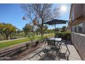 Private patio with table, chairs, and umbrella overlooking a golf course at 7800 E Lincoln Dr # 1029, Scottsdale, AZ 85250