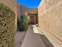 Pathway to the front door, with landscaping and a tan stucco wall at 9223 E Whitethorn Cir # 667, Scottsdale, AZ 85266