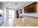 Kitchen with granite countertops and dark brown cabinets at 10332 W Devonshire Ave, Phoenix, AZ 85037