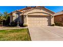 Tan stucco single-story house with a two-car garage and well-manicured lawn at 10339 N 58Th Ln, Glendale, AZ 85302