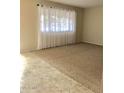 Spacious living room with tile and carpet flooring, and large window at 10526 W Crosby Dr, Sun City, AZ 85351