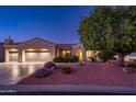 Well-lit three-car garage and desert landscaping at 12928 W Santa Ynez Dr, Sun City West, AZ 85375