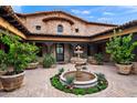 Inviting courtyard with a decorative fountain, stone accents, and lush potted plants enhancing its elegance at 16117 E Shooting Star Trl, Fountain Hills, AZ 85268