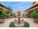 Charming courtyard featuring a stone fountain, manicured plants, and architectural stone detailing at 16117 E Shooting Star Trl, Fountain Hills, AZ 85268