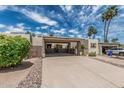 Inviting single-story home boasts desert landscaping, charming carport, and stone accents at 18718 E Rio Ln, Rio Verde, AZ 85263