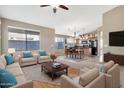 Living room with sectional sofa, coffee table, and view into kitchen and dining area at 29864 N Desert Willow Blvd, San Tan Valley, AZ 85143