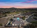 Aerial sunset view of house with pool and golf course at 319 S 227Th Ct, Buckeye, AZ 85326