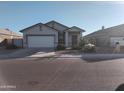 Newly built home with a two-car garage, and drought-tolerant landscaping at 36061 W Santa Clara Ave, Maricopa, AZ 85138