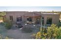 Desert landscape surrounds this stucco home with a covered porch and inviting entryway at 5341 E Windsong St, Apache Junction, AZ 85119