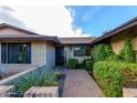 Brick front entry with a paved walkway and mature shrubs at 5345 E Evans Dr, Scottsdale, AZ 85254