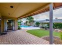 Covered patio overlooking a sparkling pool and grassy backyard at 5345 E Evans Dr, Scottsdale, AZ 85254