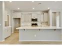 Modern kitchen with white cabinets, quartz countertops and stainless steel appliances at 5660 N 188Th Ln, Litchfield Park, AZ 85340
