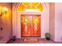 Inviting entryway with double doors, decorative wreaths, and arched window above at 15237 S 19Th Way, Phoenix, AZ 85048