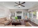 Bright living room with a ceiling fan, a stone fireplace, plush seating, and hardwood flooring at 15237 S 19Th Way, Phoenix, AZ 85048