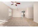 Bright living room featuring tile and carpet flooring, ceiling fan, and natural light at 17528 W East Wind Ave, Goodyear, AZ 85338