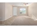 Living room with tile and carpeted floors, and a large window at 17528 W East Wind Ave, Goodyear, AZ 85338