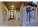 A covered entryway with stone pillars, tile flooring and rustic decor at 17716 E Silver Sage Ln, Rio Verde, AZ 85263