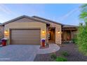 A charming single story home with a brown garage door and welcoming entryway at 17716 E Silver Sage Ln, Rio Verde, AZ 85263