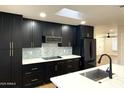 Modern kitchen with dark cabinetry, marble countertops, and stainless steel appliances at 1936 E Cornell Dr, Tempe, AZ 85283